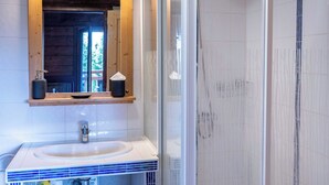 A bathroom with a wooden vanity, a sink, and a glass shower enclosure. - 1BDR/4P apartment with balcony and parking- Megève (Megève)
