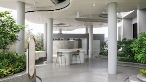 A modern indoor space with a central seating area, white columns, and a curved ceiling design. - 22 Macalisterz by Mana Mana (George Town)