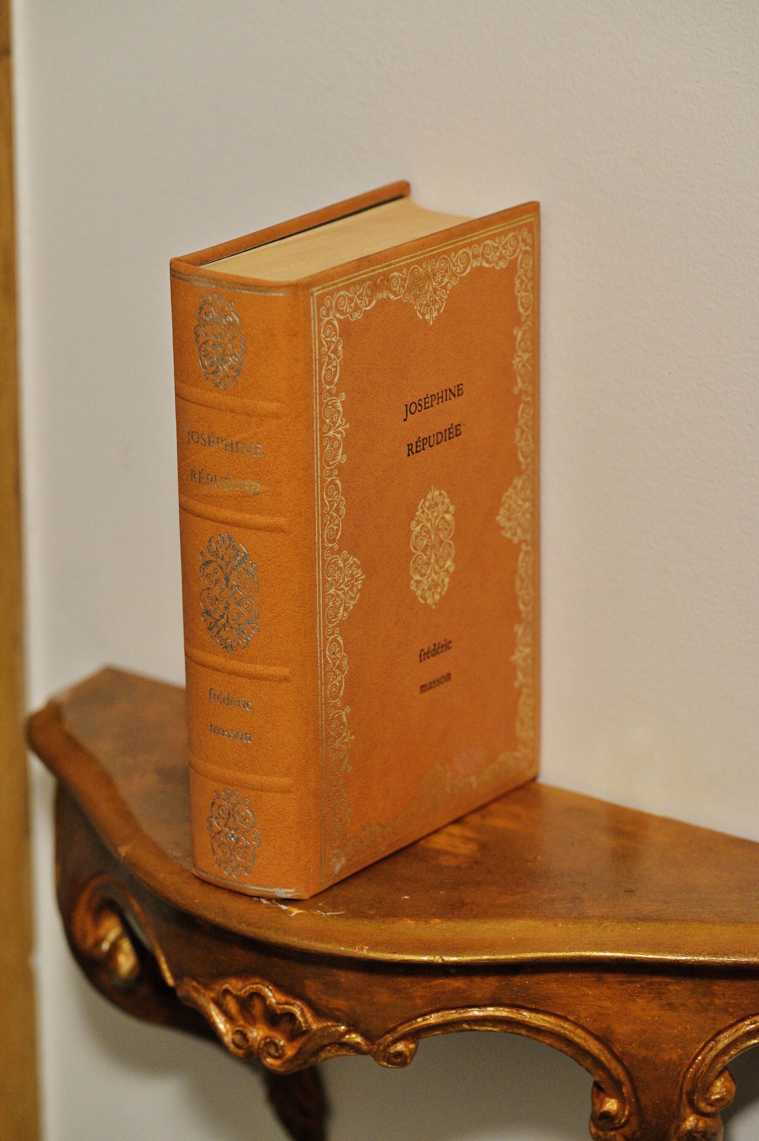 A book titled "Josephine Rédoubé" placed on a wooden table with ornate carvings.