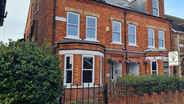 A traditional brick building with a sign indicating it is a guest house. - Crittlewood Guest House (Gainsborough)