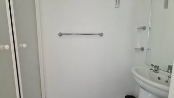 A bathroom with a white sink, mirror, and a towel rack.