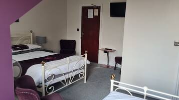Un dormitorio con dos camas, un escritorio, una silla y una puerta.