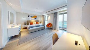 A modern hotel room with a large bed, a desk, a chair, and a view of the sea. - Luxurious 1 Bedroom-High floor-Sea view and Balcony (Dubai)