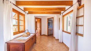 Ein Flur mit Holzbalken, einem Holzschrank und Blick ins Badezimmer.