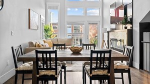 Un comedor moderno con una mesa de madera, sillas y un sofá.