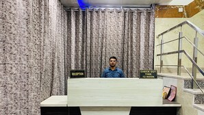 Mostrador de recepción con un cartel que indica 'Recepción' y 'Hora de salida: 12 del mediodía'.