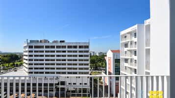 A high-rise building with multiple balconies and a rooftop area.