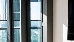 Un interior moderno con grandes puertas de vidrio que dan a un espacio exterior, una consola minimalista con un candelabro, y un diseño sencillo y limpio.