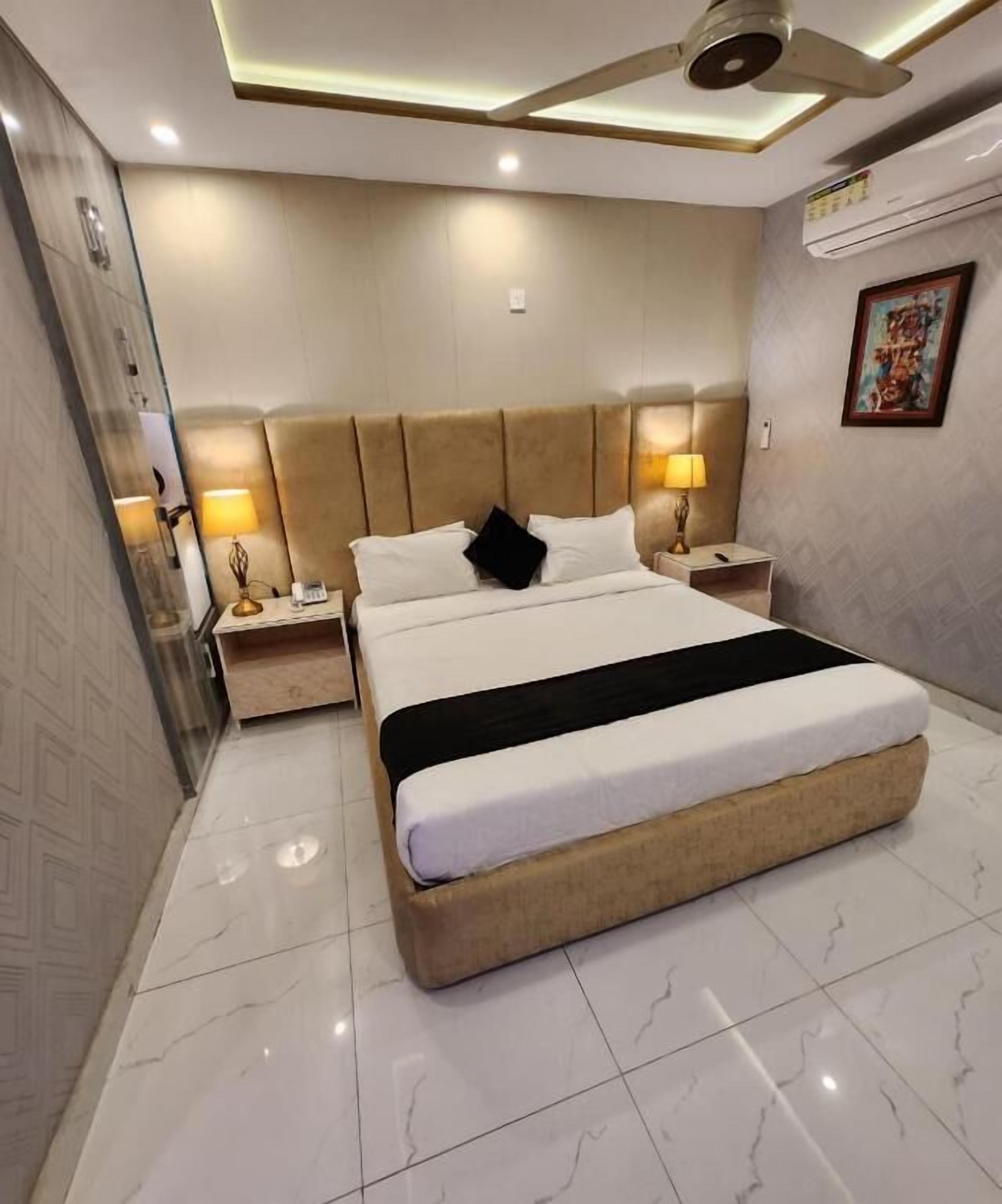 A modern bedroom with a large bed, two bedside tables, and a ceiling fan.