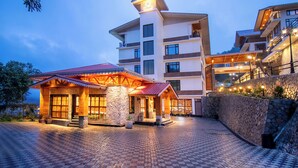 A hotel with a stone facade, a red roof, and a well-lit entrance. - Udaan Yalley Resort & Spa Gangtok (Gangtok)