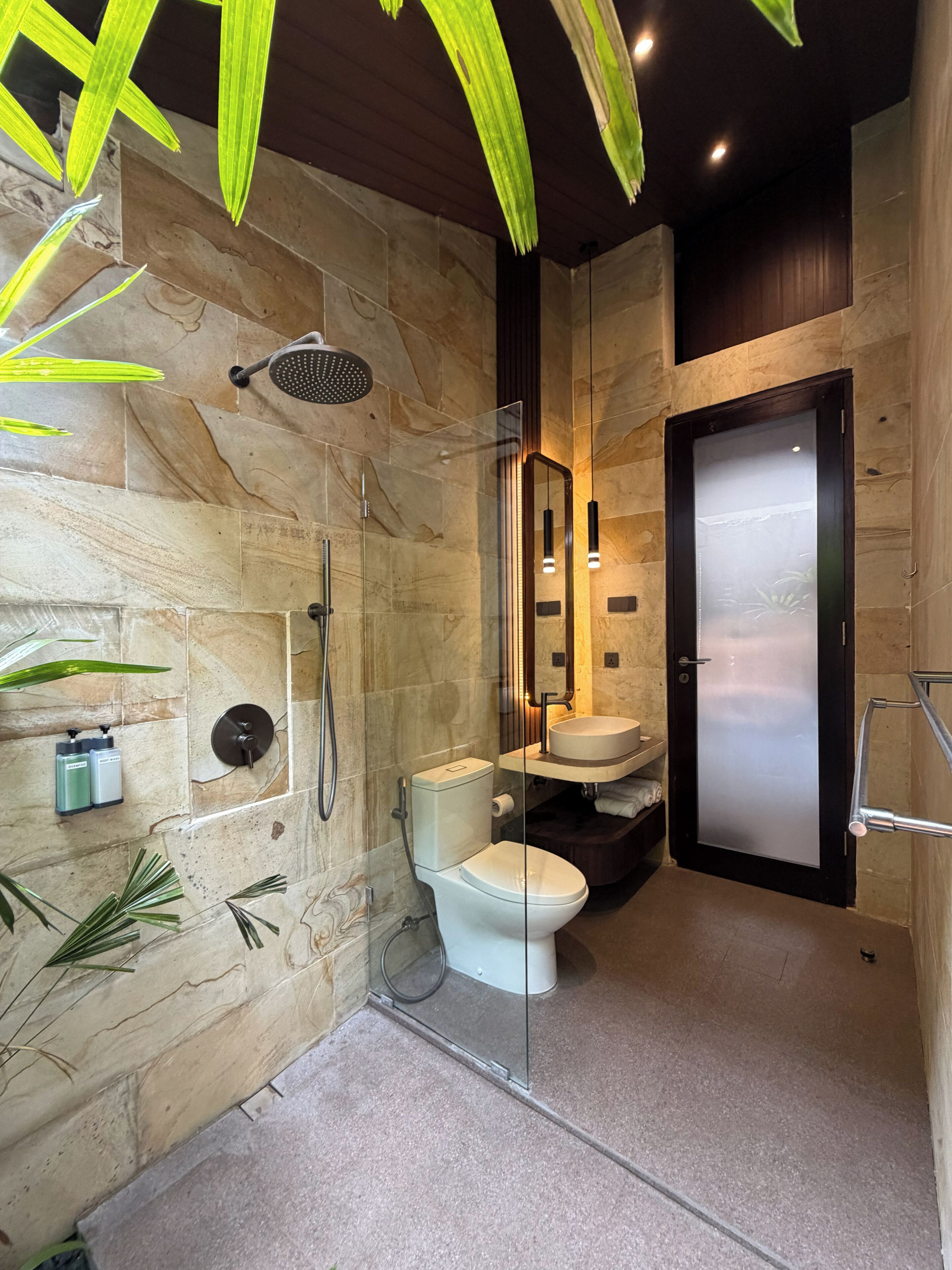 Une salle de bain moderne avec une douche à parois de verre, des toilettes et un lavabo.