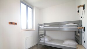 A bunk bed room with a window, a radiator, and a light fixture. - Le Logis de Lucie ( 6 people) (Lys-Haut-Layon)