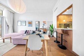 A modern living room with a sofa, dining table, and bar area. - StayShort - Stylish 1-Bedroom Retreat in JVC that Sleeps 2 (JVC)
