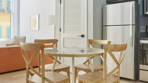 Eine moderne Küche mit einem weißen Kühlschrank, Holzstühlen und einem Esstisch.