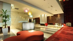 A modern hotel lobby with a reception desk, a red seating area, and a red carpet. - Empire Suites Subang by Mana Mana (Subang Jaya)
