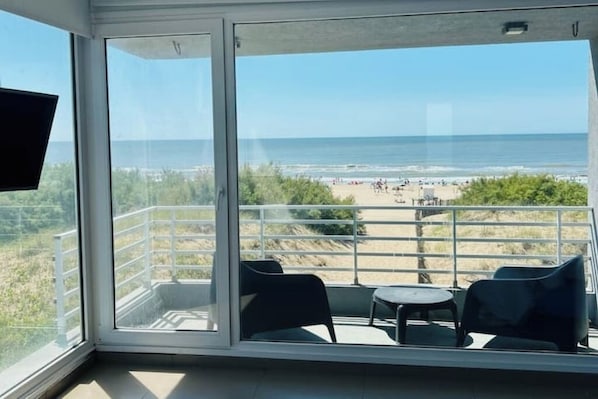 Ein Balkon mit Blick auf Strand und Meer.
