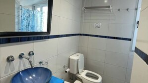 Ein Badezimmer mit blauem Waschbecken, Toilette und Spiegel.