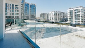 Un appartement moderne doté d’un balcon donnant sur un paysage urbain.