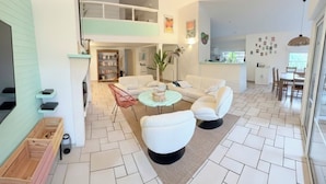 A spacious living area with a high ceiling, a dining area, and a kitchen visible in the background. - Villa private heated pool, 4 bikes, nearby beach, surf 🌊 (Moliets-et-Maa)