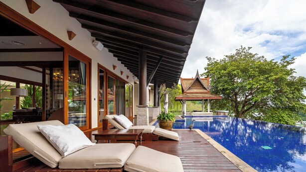 A wooden deck with lounge chairs and a swimming pool. - Royal Legacy Golf Villa (Rawai)