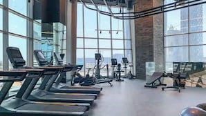 Une salle de sport équipée de tapis de course, de vélos d’appartement et d’appareils de musculation elliptique.