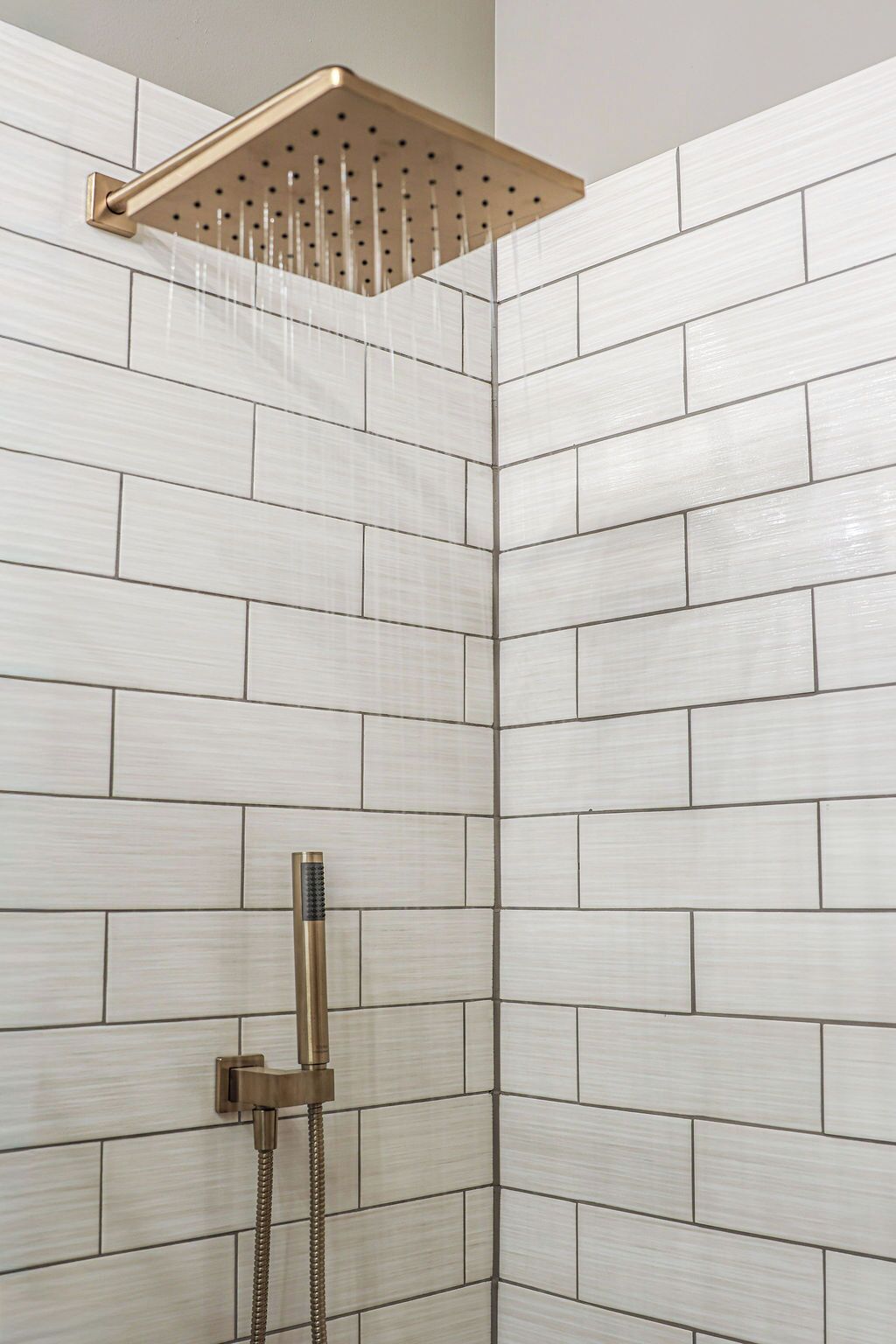 Ein Duschbereich mit modernem Design, ausgestattet mit einer Eckdusche und einer Handbrause.