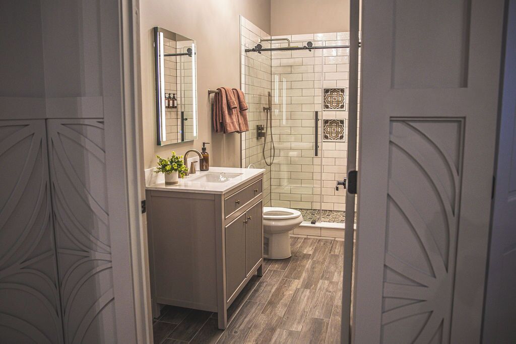 A modern bathroom with a shower, toilet, and vanity.