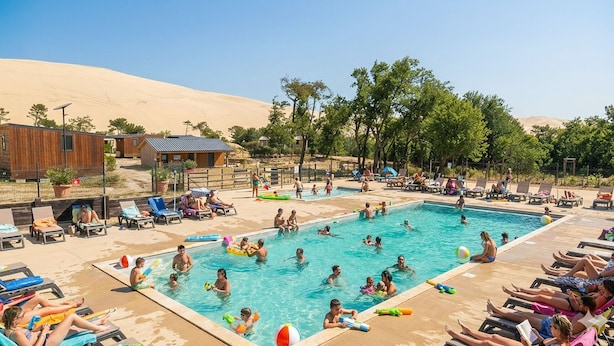 Zona de piscina con sillas de descanso y paisaje desértico al fondo.