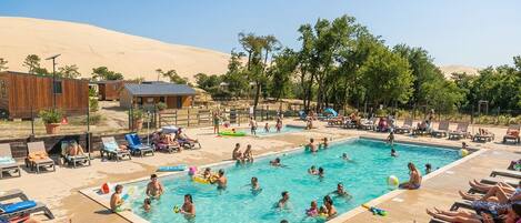 Una piscina al aire libre de temporada, sillones reclinables de piscina