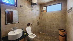 Une salle de bain avec un grand miroir, un lavabo, des toilettes, une douche et une fenêtre.