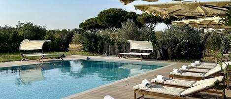 A poolside area with lounge chairs and umbrellas.