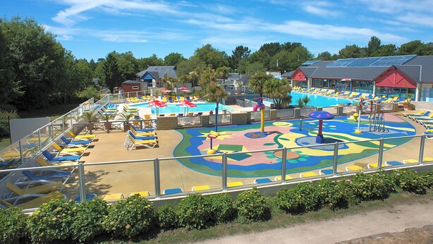 Ein Poolbereich mit Liegestühlen und einem bunten Spielbereich.