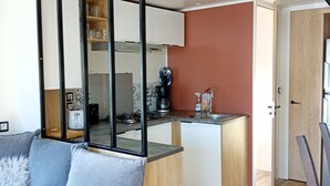Eine moderne Küche mit weißen Schränken, einer Holzauskładung und einer roten Akzentwand.