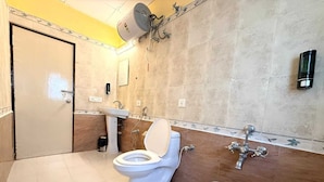 A bathroom with a toilet, sink, and shower. - Laavish 7 Hotel (Bengaluru)