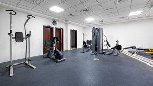 A gym with various exercise equipment, including treadmills, stationary bikes, and weight machines. - StayShort - Stylish Studio Apartment in Sports City - Sleeps 2 (Sports City)