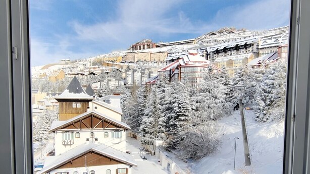 A view from a window of a hotel with a snowy landscape, including a building labeled "KENIA NEVADA HOTEL".