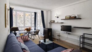 A modern living room with a sofa, TV, and dining area.