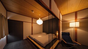 Een kamer met een bed, een stoel en een lamp.