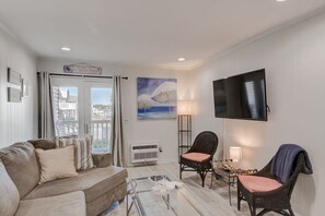 A living room with a sofa, two chairs, a flat-screen TV, and a painting on the wall. - Inlet Facing 1st Floor 2B/2B Condo w/pool (North Myrtle Beach)
