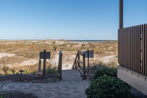 A pathway leading to a beach with a wooden fence and a signboard. - Inlet Point Villas 1br/1b oceanfront w/pool 13D (North Myrtle Beach)