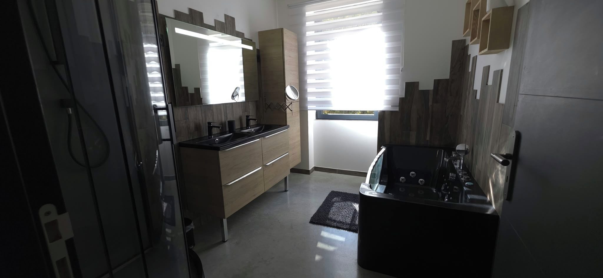 Un baño moderno con tocador, espejo y bañera.