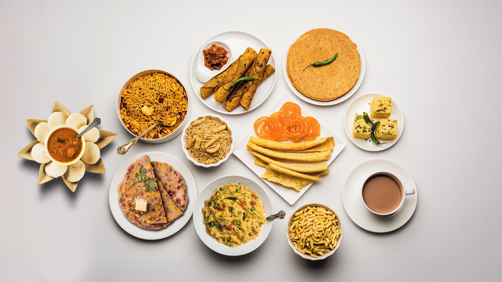 Variedad de platos de la India, como naan, samosas y una taza de té.