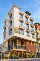 Um hotel com vários andares, varandas, uma placa com o texto 'RAW LEAVES' e um design arquitetônico moderno.