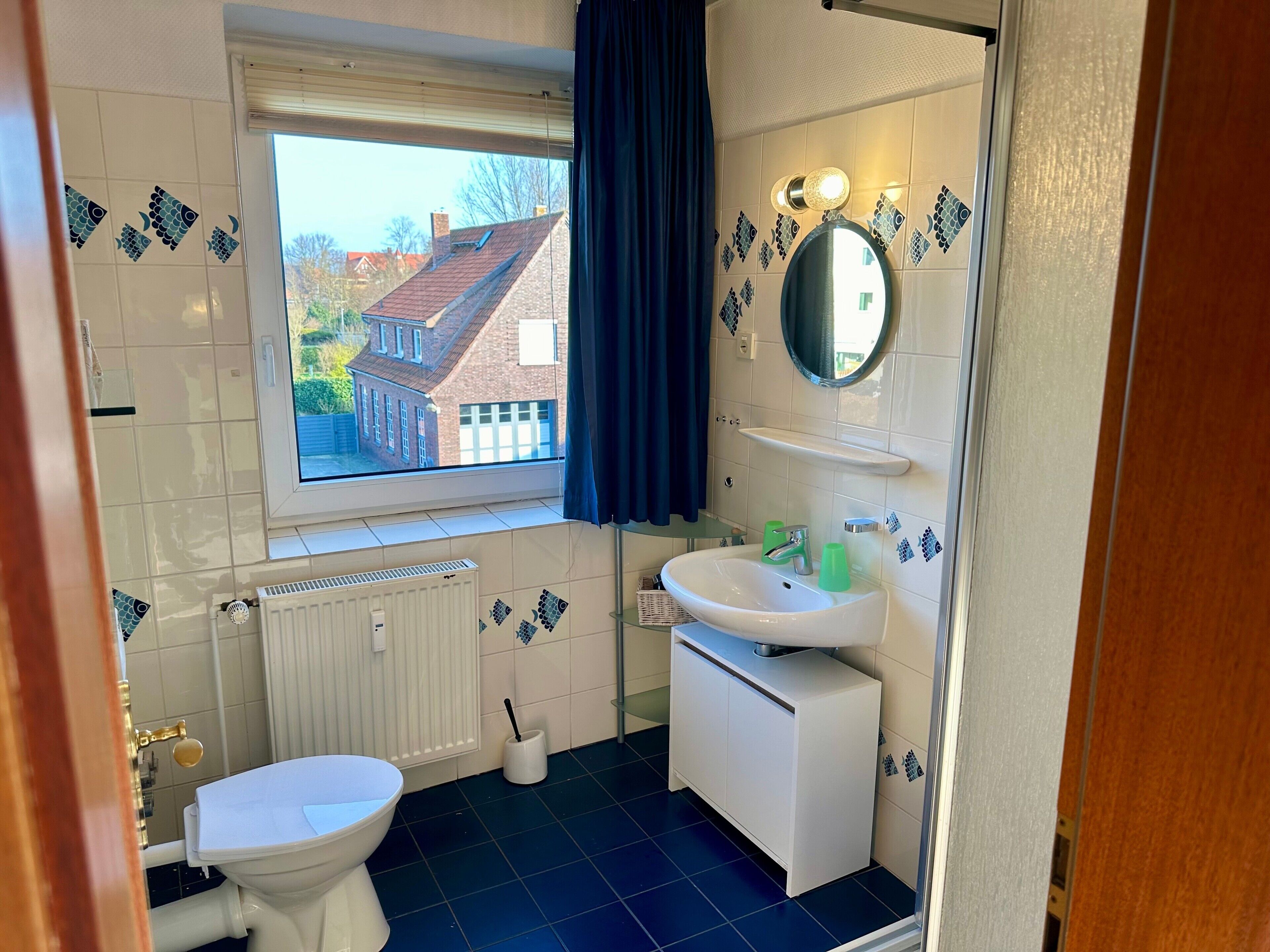 Ein Badezimmer mit Toilette, Waschbecken und Fenster.