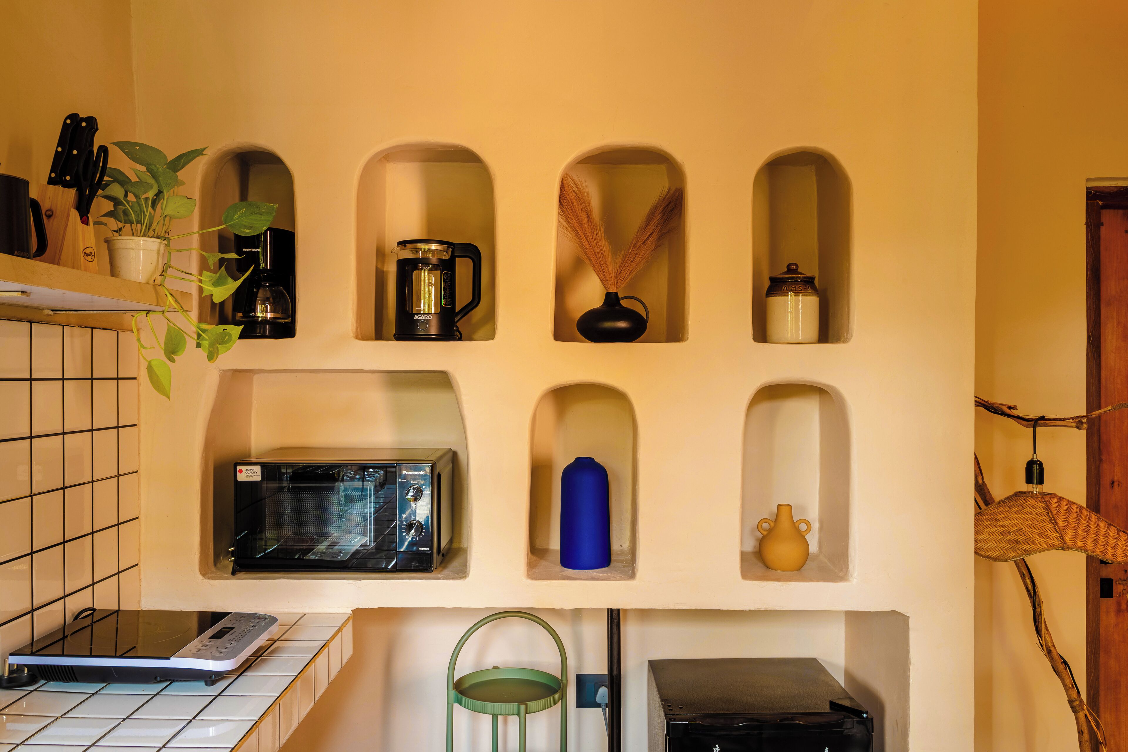 Une cuisine équipée d’un four à micro-ondes, d’une machine à café et de divers ustensiles de cuisine.