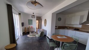 Un espacio habitable moderno con comedor, cocina y sofá.