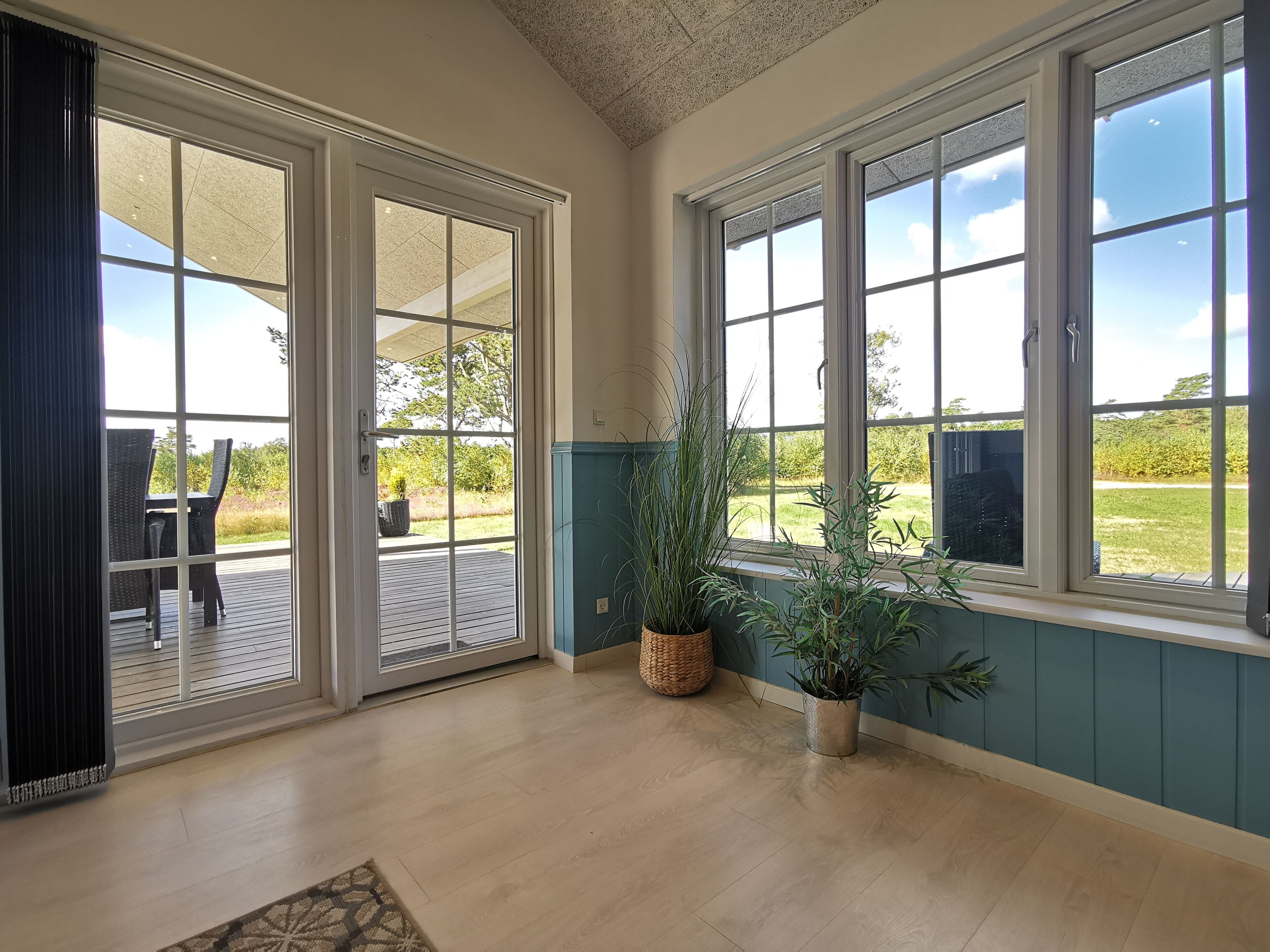 Een ruime kamer met grote schuifdeuren naar een terras.