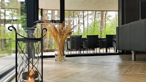 A modern interior with a large window, a glass vase with dried plants, a candle holder, and a sofa. - Modern Holiday Home on Læsø, Style, Space, and Scandinavian Charm (Læsø)