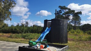 A playground with a blue slide and a sandbox. - Panoramic Views and Luxurious Comfort on Læsø Island and Sleeps up to 16 Persons (Læsø)