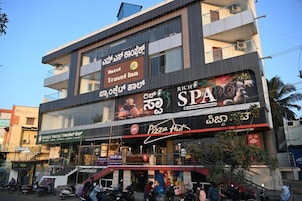 Un edificio de varios pisos con letrero de hotel, posada, spa y Pizza Hut.